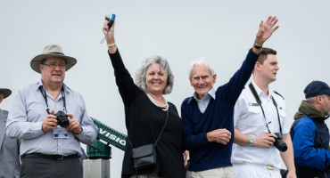 Two people looking happy wave to the camera