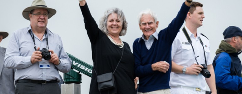 Two people looking happy wave to the camera