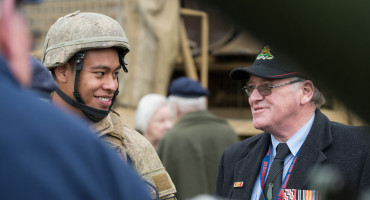 Current soldier talking with retired veteran