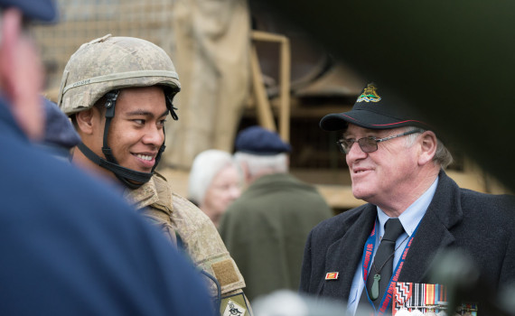 Current soldier talking with retired veteran