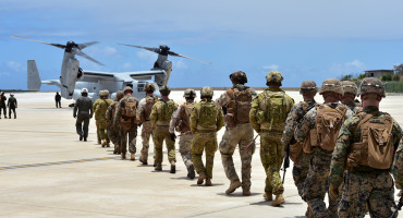 Soldiers of different militaries approach an aircraft