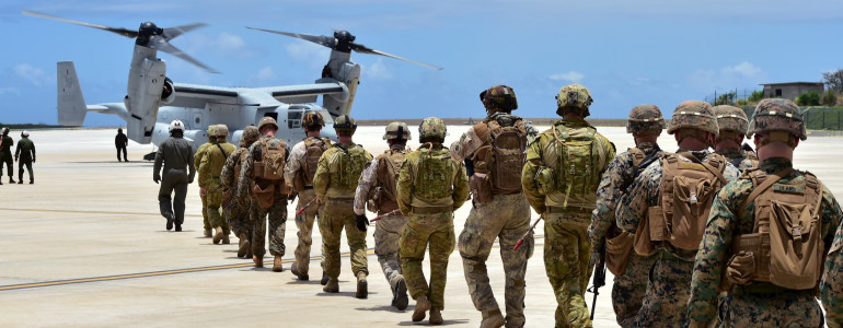 Soldiers of different militaries approach an aircraft