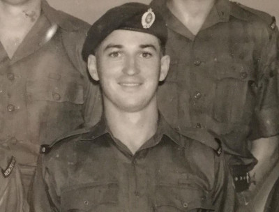 Black and white photo of a young man in a military uniform 