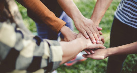 A circle of hands meeting in the middle