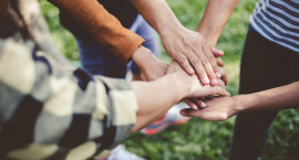A circle of hands meeting in the middle