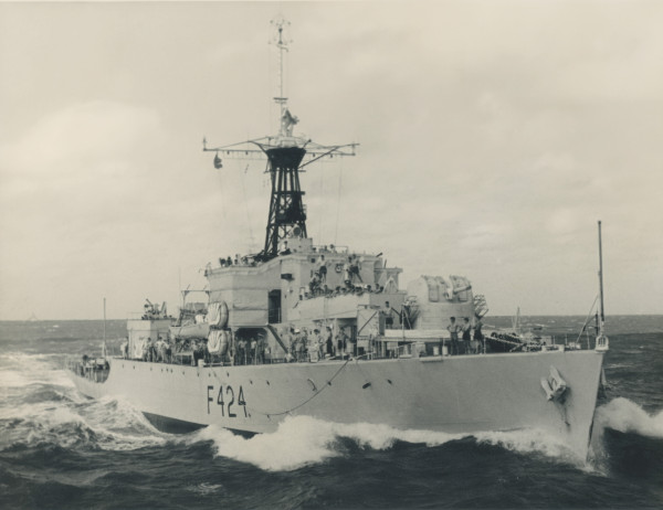 A large metal ship sailing through the open ocean.