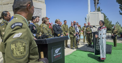 Hon. Meka Whaitiri speaking in front of 30 service personnel at a war memorial