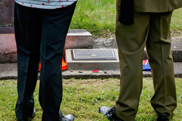 Close up of two people standing over a new plaque