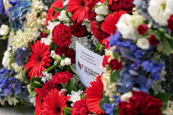 A circular wreath of flowers with a note in the middle