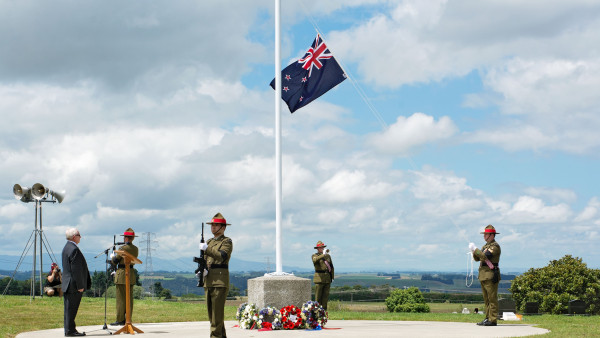 Two planes flying over soldiers in uniform at attention