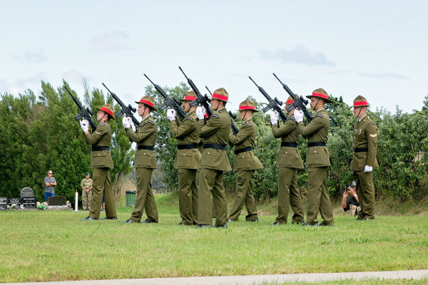 Soldiers in uniform fire blank rounds into the sky