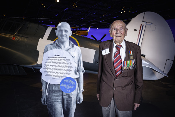 Mr Hermanns standing with a cut-out figure of his younger self at the Air Force Museum of New Zealand