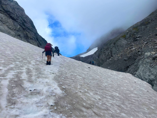 Two people hiking up a snowy mountain