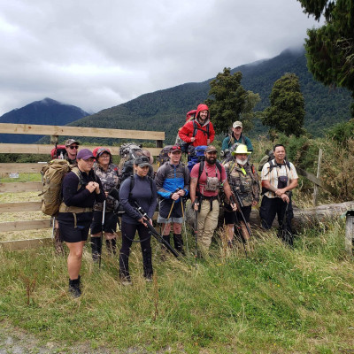 A group of people in grassy mountains wearing hiking gear