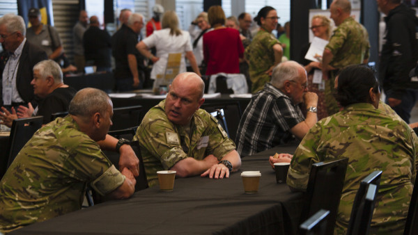 Uniformed men talking at an event