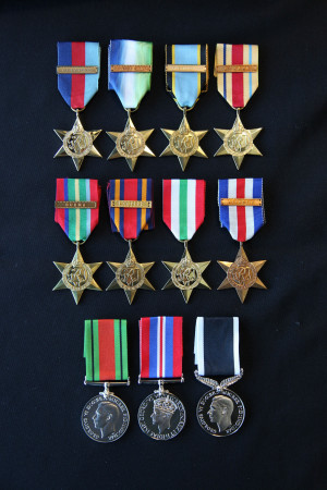 8 Star medals and 3 circular medals lain flat on a table