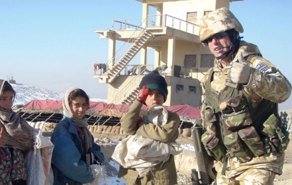 Brett Te Wheoro standing with Afghani children