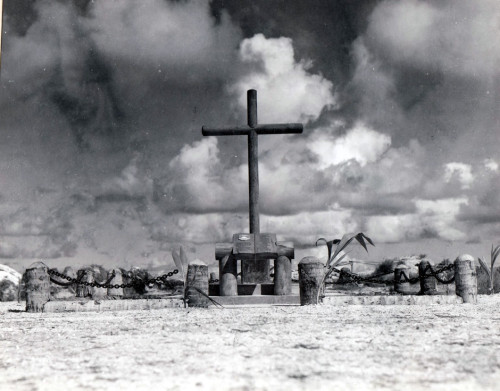 A wooden cross memorial on a beach