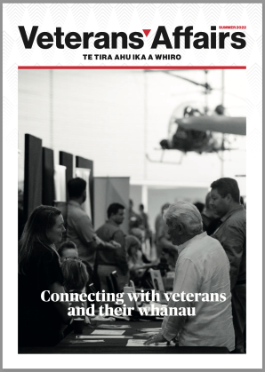 Magazine cover of a man and woman talking at an event for veterans